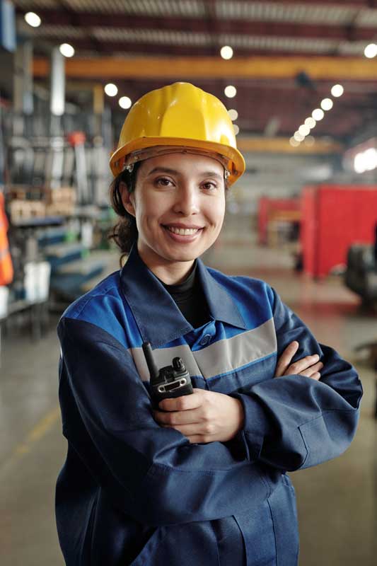 Woman technician in PPE and handheld-receiver smiling